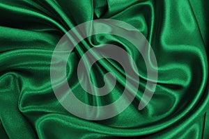 Smooth elegant green silk or satin luxury cloth texture as abstract background. Luxurious background design