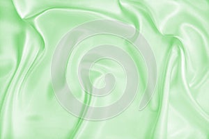 Smooth elegant green silk or satin luxury cloth texture as abstract background. Luxurious background design