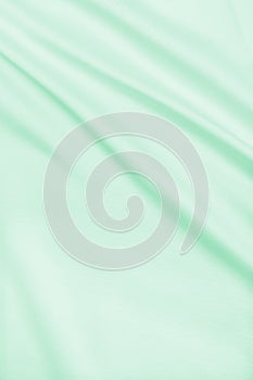 Smooth elegant green silk or satin luxury cloth texture as abstract background. Luxurious background design