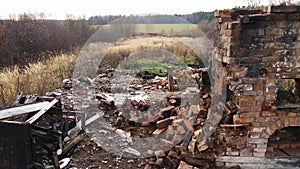 A smooth flight over a completely burnt building with a red brick oven.