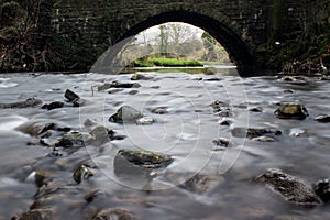 Smooth flowing stream beneath a bridge.  Pendleton brook in Clitheroe, Ribble valley photo