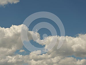 Smooth fluffy cumulus clouds in summertime sky. Warm evening colour, copy space, place for text