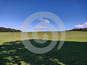 Smooth grassy hill and horizon under a blue sky
