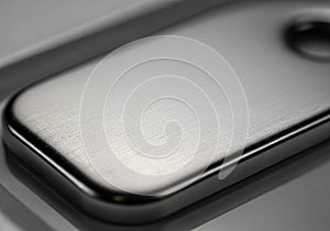 Smooth, metallic surface with a brushed texture, featuring a rounded rectangular shape and a small