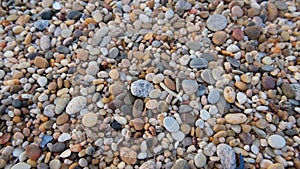 Smooth round pebbles on beach in Portugal. Natural background texture.