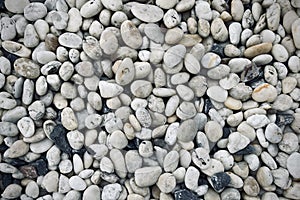 Smooth round pebbles texture background. Pebble sea beach close-up, dark wet pebble and gray dry pebble