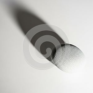 The shadow gradates from dark to light, reflecting the stone's