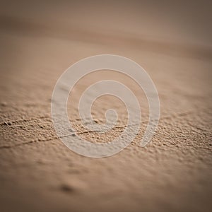 Smooth sandy surface with fine, granular texture in a soft beige color. The image