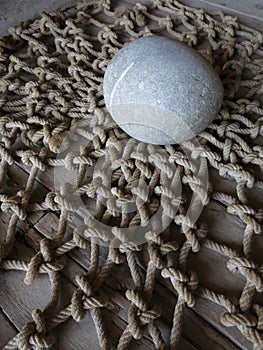 Smooth stone on a fish net