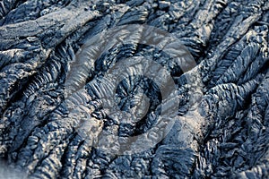 Smooth, undulating surface of frozen pahoehoe lava. Frozen lava wrinkled in tapestry-like folds and rolls resembling twisted rope photo