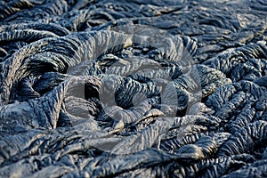 Smooth, undulating surface of frozen pahoehoe lava. Frozen lava wrinkled in tapestry-like folds and rolls resembling twisted rope photo