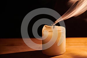 Smooth, white beautiful smoke from candle. Extinguished candle on wooden table