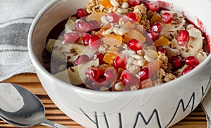 Smoothie acai bowl topped with pomegranate, bananas, flaxseeds, cedar seeds, dried apricot and granola. Acai breakfast superfoods