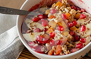 Smoothie acai bowl topped with pomegranate, bananas, flaxseeds, cedar seeds, dried apricot and granola. Acai breakfast superfoods