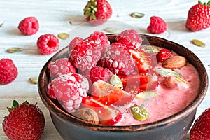 Smoothie berry bowl with strawberry, raspberry, nuts and seeds for healthy breakfast