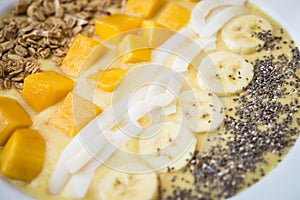 Smoothie bowl with Banana, coconut, mango, granola and chia seeds