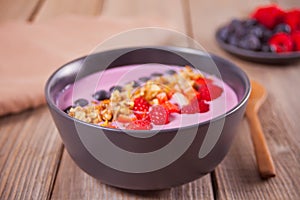 Smoothie bowl with berries on a wooden table