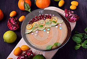 Smoothie bowl garnished with kumquats, pomegranate, lime and mint