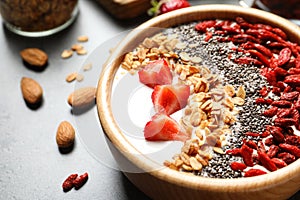 Smoothie bowl with goji berries on grey table