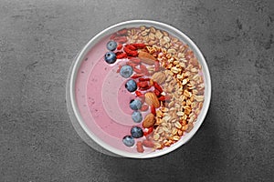 Smoothie bowl with goji berries on grey table