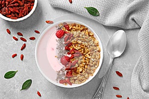 Smoothie bowl with goji berries on grey table