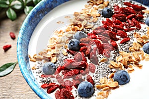 Smoothie bowl with goji berries on wooden table