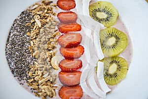 Smoothie bowl with strawberry, coconut, kiwi, granola and chia seeds