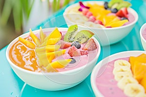smoothie bowls garnished with fresh tropical fruit slices on a bright caf table photo