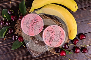 Smoothie with cherry banana and chia seeds on a wooden background.Flet ley.
