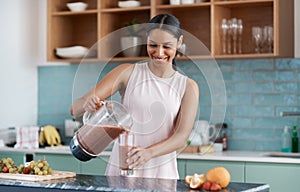 A smoothie cures all. an attractive young woman making smoothies in her kitchen at home.