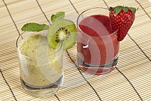 Smoothie of kiwi and strawberry on a straw mat