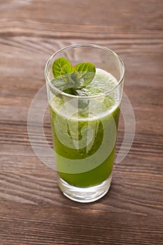 Smoothies green dietary vegetarian on a wooden table with mint l