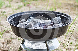 Smouldering charcoal in small grill