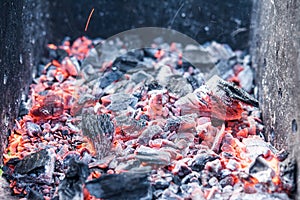 Smouldering coals at barbeque campfire