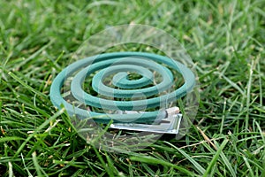 Smouldering insect repellent coil on grass outdoors