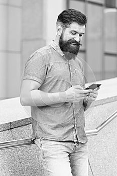 SMS chat online. Happy hipster text SMS via smartphone urban outdoor. SMS messaging. Short message service. Texting SMS