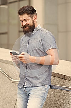 SMS chat online. Happy hipster text SMS via smartphone urban outdoor. SMS messaging. Short message service. Texting SMS