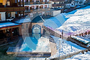 Aerial shot of wooden houses in the middle of the mountains in the Austrian Alps during winter