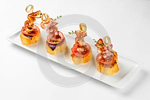 Snack canapes on a white glass plate. Catering service