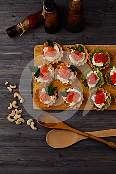 Snack, nuts and cherry tomatoes on a dark wooden background