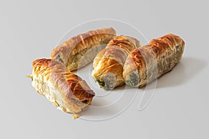 Snack of puff pastry rolls with a golden crust stuffed with spinach and cheese photo