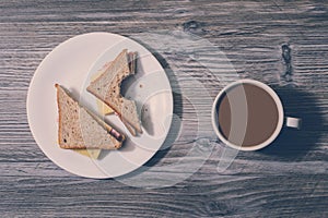 Snack rest relax chill out fast food eating junk unhealthy nutrition concept. At work. Bitten cheese sandwich with crumbs on a whi