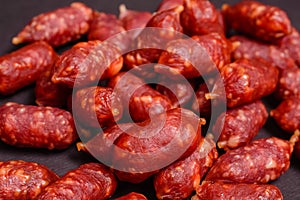 Snack to beer. Small sausages to frothy drink. Background of sausages on a dark background close-up