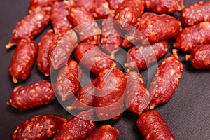 Snack to beer. Small sausages to frothy drink. Background of sausages on a dark background close-up