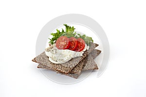 Snack from wholegrain rye crispbreads with Cherry tomatoes, salad and goat cheese