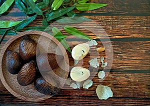 Snackfruit and leaves on wood background