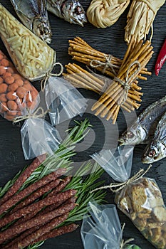 Snacks for beer. Set for beer. Nuts, crackers, fried potatoes in strips. View from above. Dark wooden background