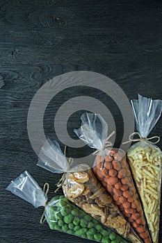 Snacks for beer. Set for beer. Nuts, crackers, fried potatoes in strips. View from above. Space for text. Dark wooden background