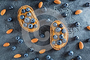 Snacks with bread, peanut butter and blueberries. Healthy food concept. Flat lay, top view