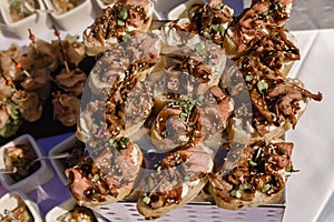 Snacks and canapes and tartlets stuffed in the assortment on the buffet table.